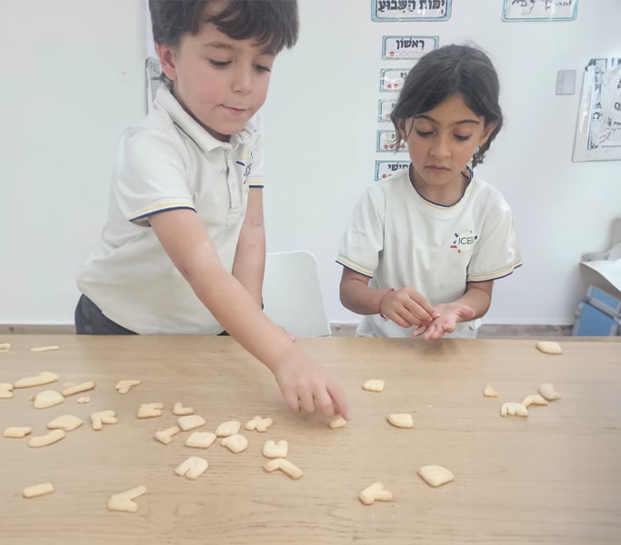 Two children sorting wooden counting tokens at a classroom table