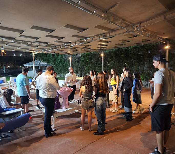 Adults gathered under a canopy for a nursery community event