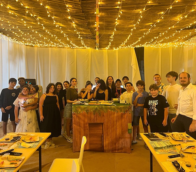 Evening event with fairy lights and families gathered around tables