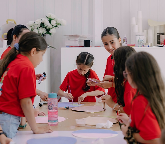 Children enjoying an arts and crafts session with a teacher