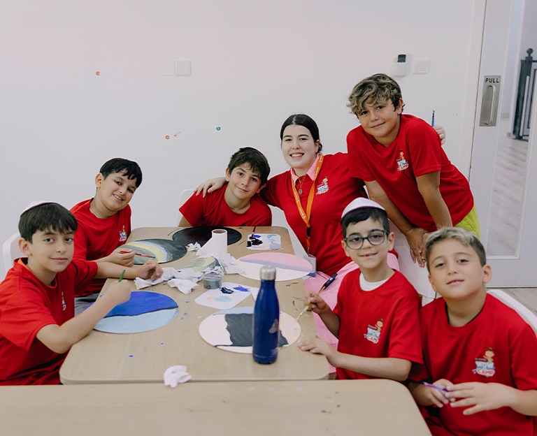 Group of kids in red uniforms sitting at a classroom table