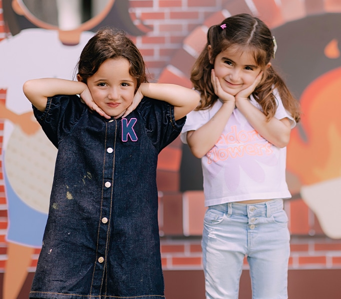 Two smiling girls posing together during a school event